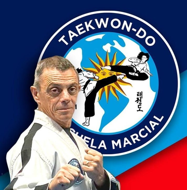 El Maestro Jorge D. Prieto en posición de guardia, con el logo de la escuela de fondo